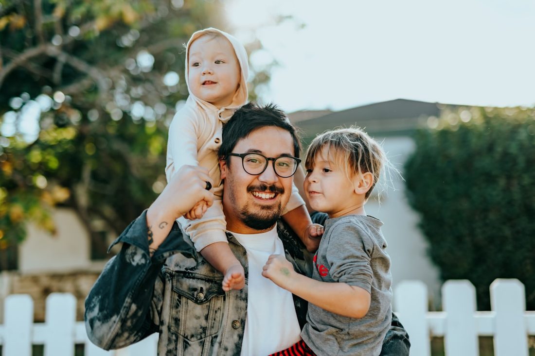 Father carrying his kids outside their home